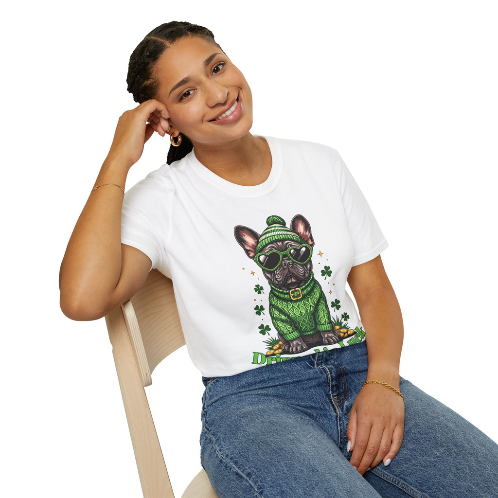 Person wearing a white t-shirt with a graphic of a dog in a green sweater and hat, sitting on a chair.