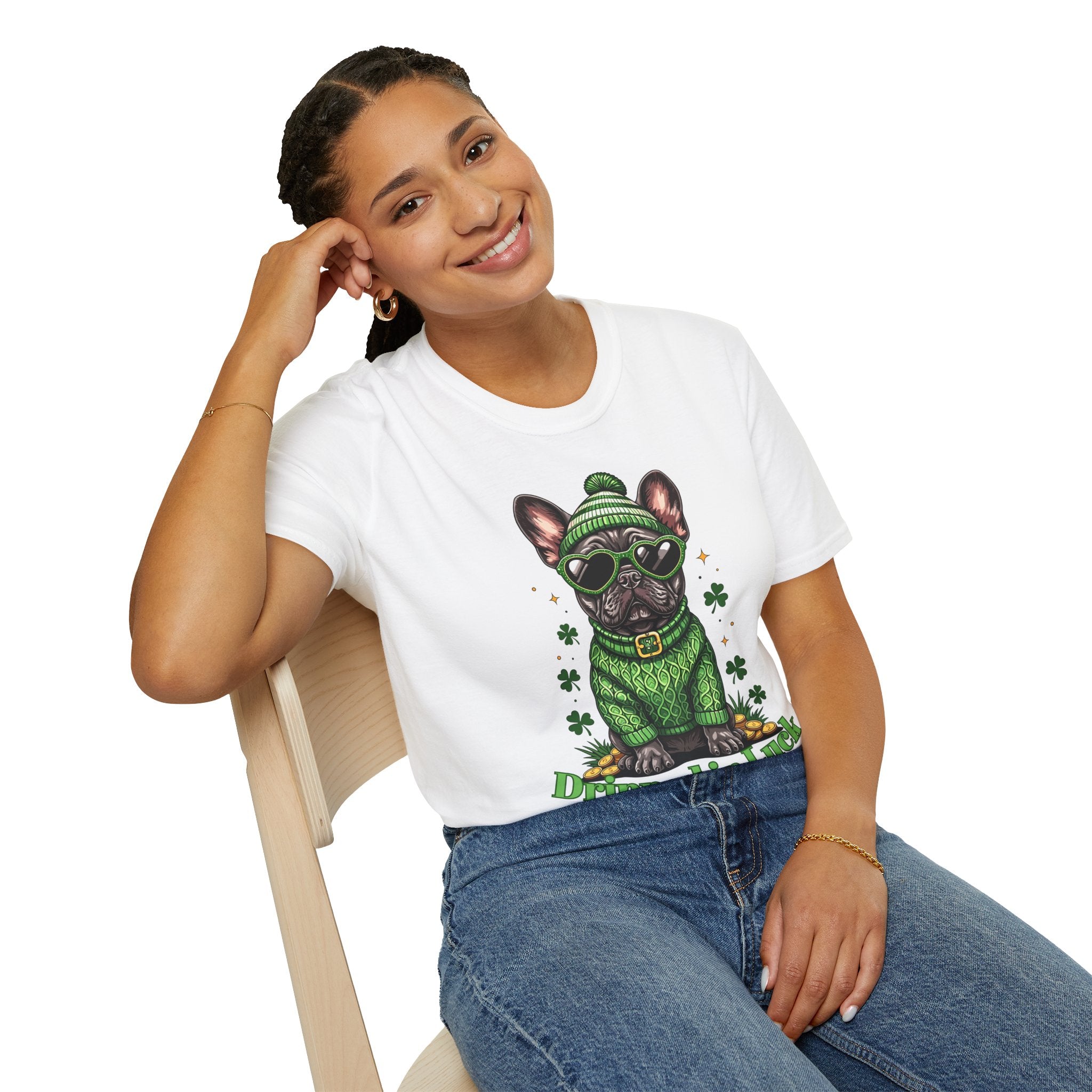 Person wearing a white t-shirt with a graphic of a dog in a green sweater and hat, sitting on a chair.